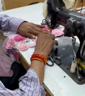 Artisan stitching rose appliqué on a sewing machine